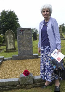 Neice of Robert  Nicholson laying poppies on grave A4 Web UMHPP1090662